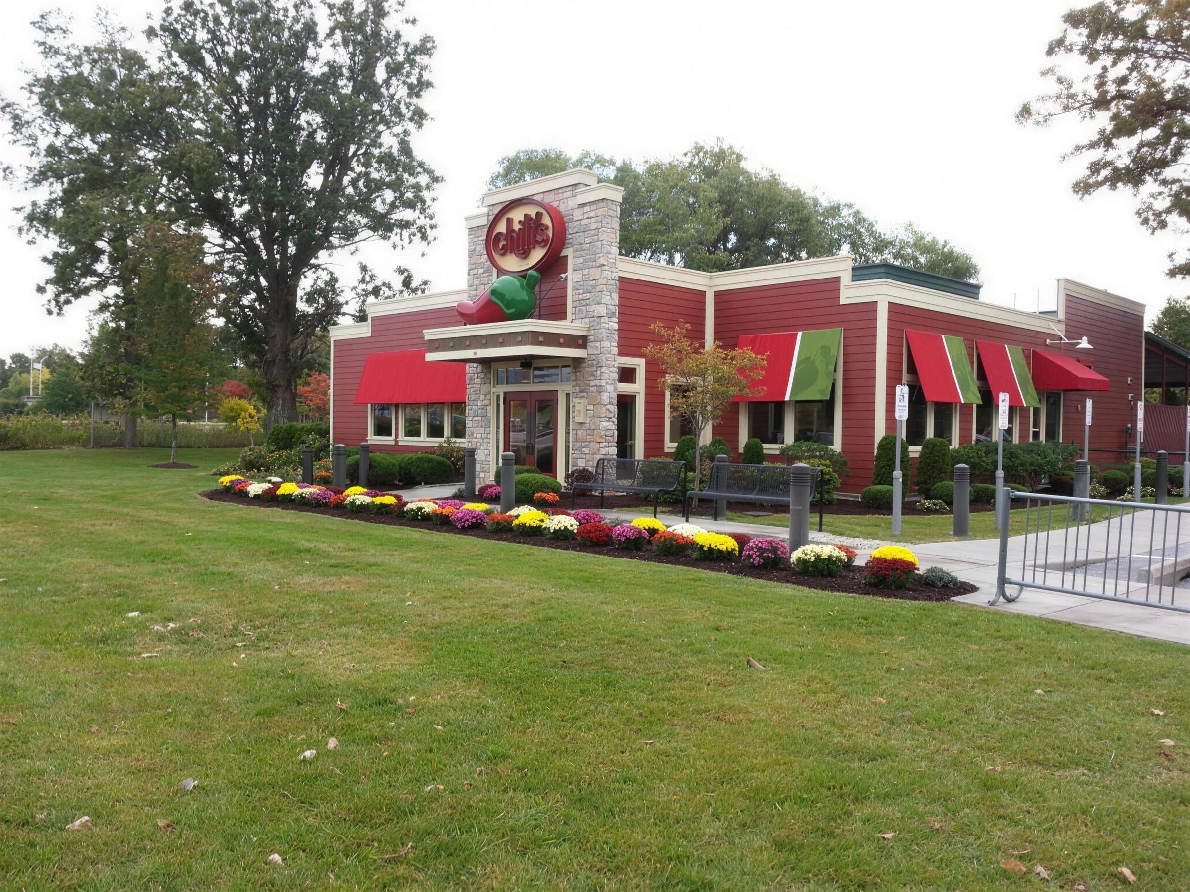 Colorful annual flower beds and pruned shrubs at a commercial restaurant property