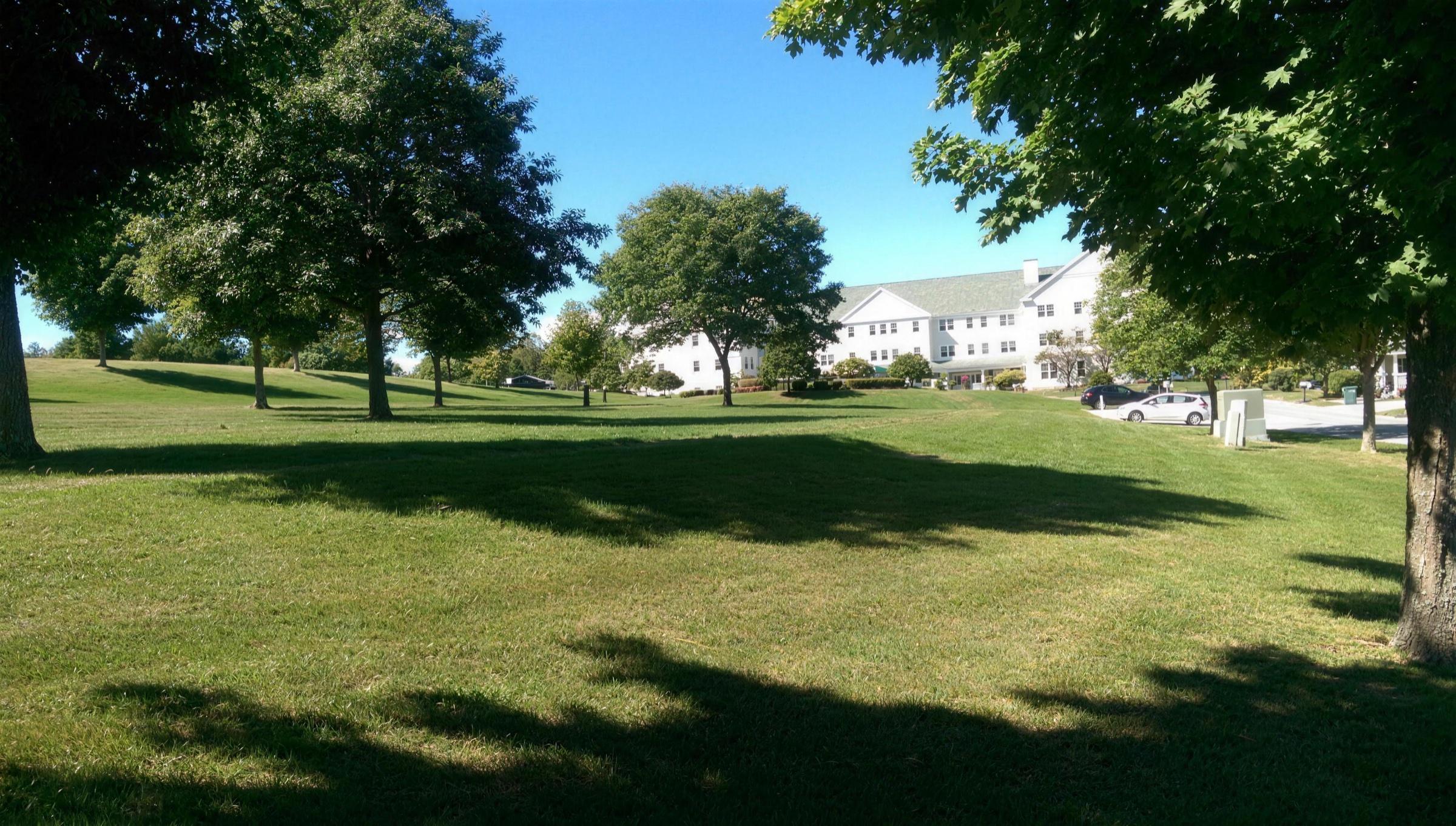 Senior-living campus with broad lawns and mature shade trees